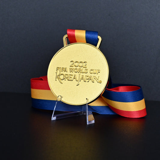2002 FIFA World Cup Korea Japan Brazil Champions Medal - Front View with Blue FIFA Ribbon & Acrylic Stand, Featuring Tournament Text Engraving, Premium Alloy Football Collectible
