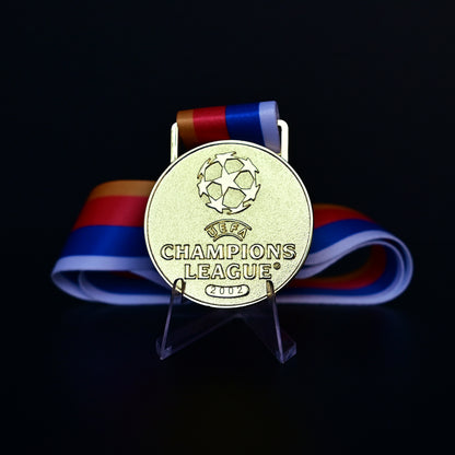UEFA Champions League Medal Front View, Porto Champion Gold Alloy Medal with Official UCL Logo, 2002 Final Commemorative Medal on Clear Display Stand with Blue Tournament Ribbon