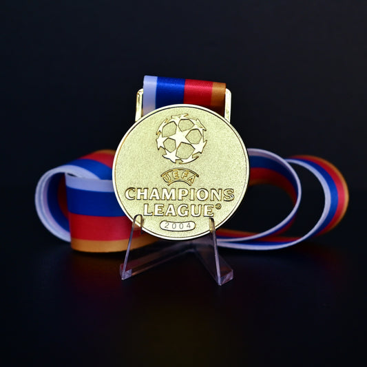 2004 UEFA Champions League Medal Front View, Porto Champion Gold Alloy Medal with Official UCL Logo, 2004 Final Commemorative Medal on Clear Display Stand with Blue Tournament Ribbon