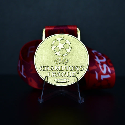 2005 UEFA Champions League Medal Front View, Liverpool Champion Gold Alloy Medal with Official UCL Logo, 2005 Final Commemorative Medal on Clear Display Stand with Blue Tournament Ribbon