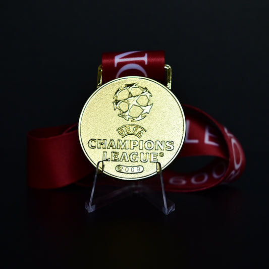 2009 UEFA Champions League Medal Front View, Barcelona Champion Gold Alloy Medal with Official UCL Logo, 2009 Final Commemorative Medal on Clear Display Stand with Blue Tournament Ribbon