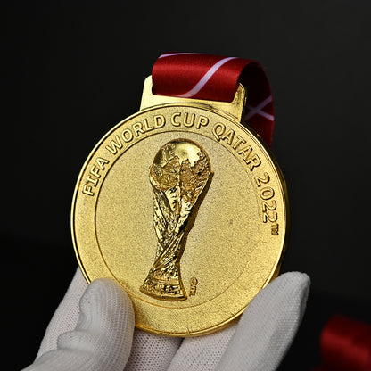 2022 FIFA World Cup Qatar Argentina Champions Medal - Front Close-Up Held in White Gloves, Detailed 3D FIFA World Cup Trophy Embossment & "FIFA WORLD CUP QATAR 2022" Engraving, Premium Alloy Collectible