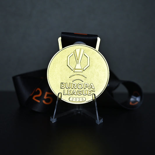 Gold Europa League 2025 coin on a stand with a dark background