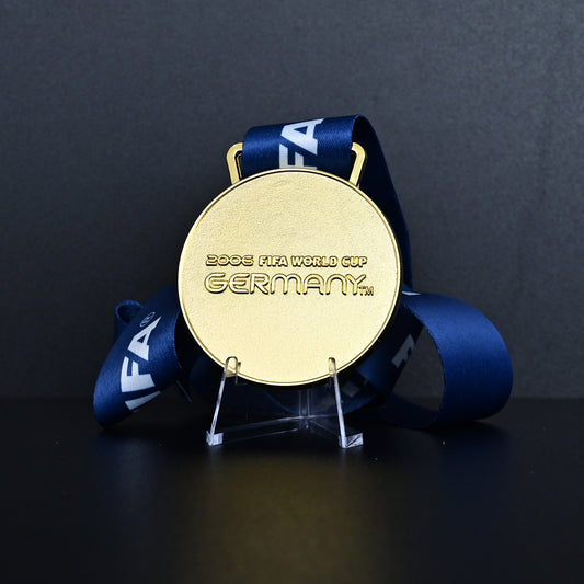 Germany 2006 FIFA World Cup Italy Champions Medal - Front View with Blue FIFA Ribbon, Featuring "2006 FIFA WORLD CUP GERMANY" Engraving, Premium Alloy Football Collectible