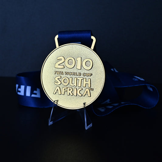 South Africa 2010 FIFA World Cup Spain Champions Medal - Front View with Blue FIFA Ribbon, Featuring "2010 FIFA WORLD CUP SOUTH AFRICA" Engraving